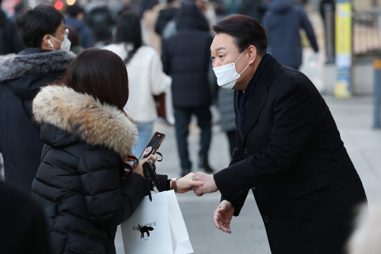 국민의힘 윤석열 대선 후보가 6일 오전 서울 여의도역 인근에서 시민과 인사를 나누고 있다. 국회사진기자단